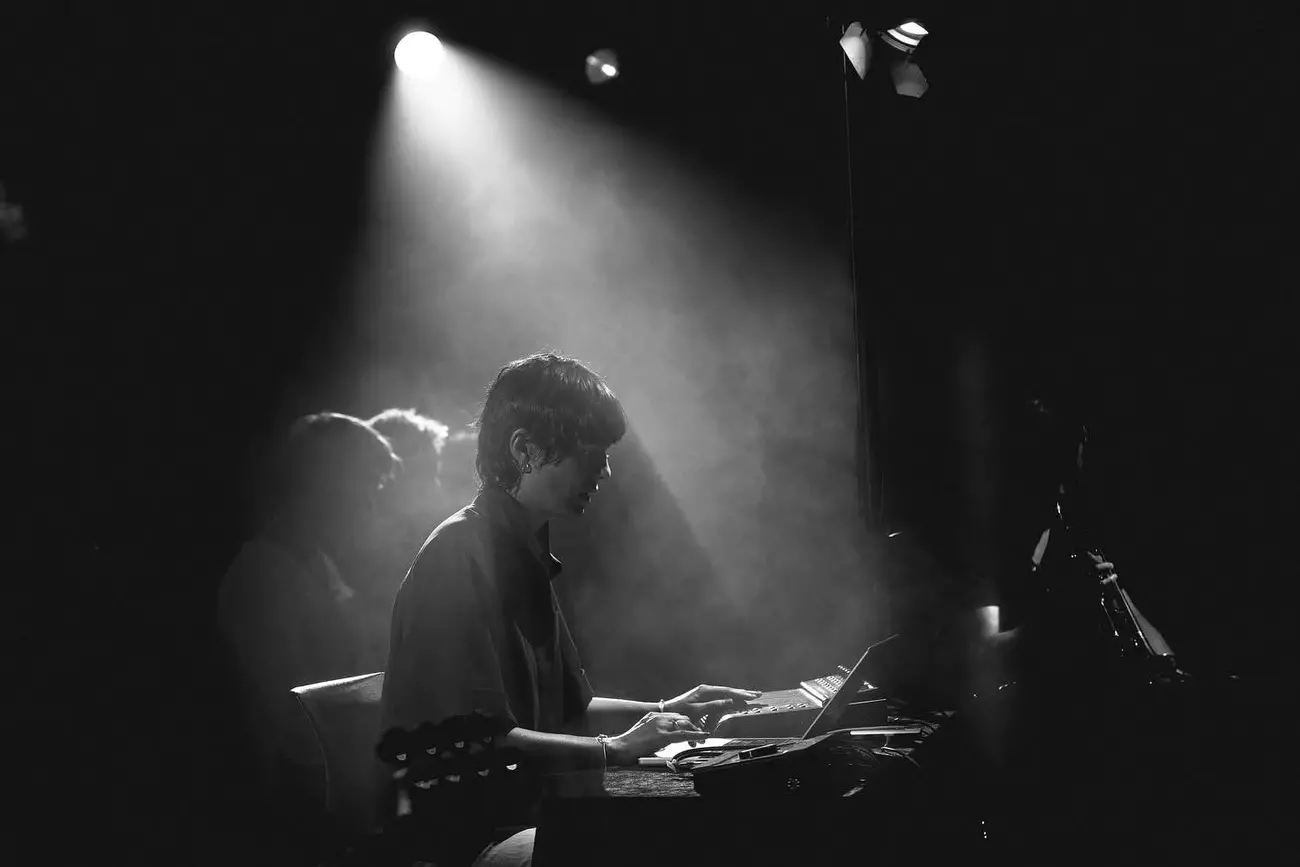 Picture of artist in a dark room with light playing. 