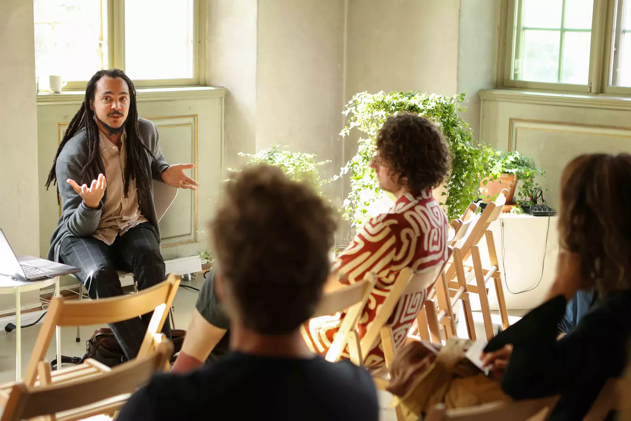 four people talking in a light room