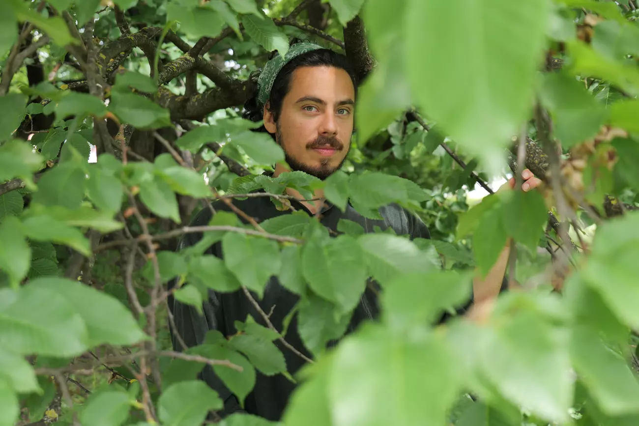 Luis Fernando Amaya surrounded by green leaves
