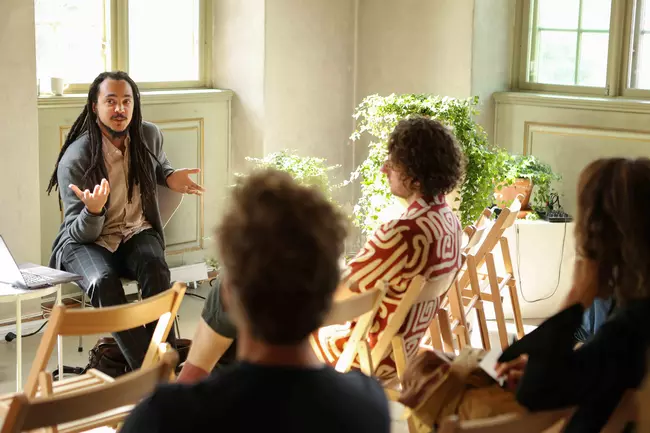 four people talking in a light room